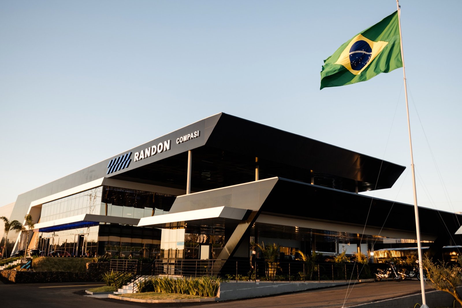 Sede da Compasi ao entardecer com a bandeira do Brasil